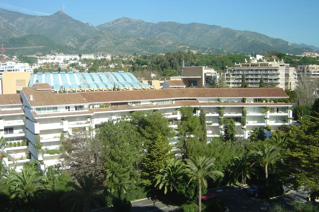 Rooftops of Marbella apartment buildings with the Sierra Blanca mountains behind