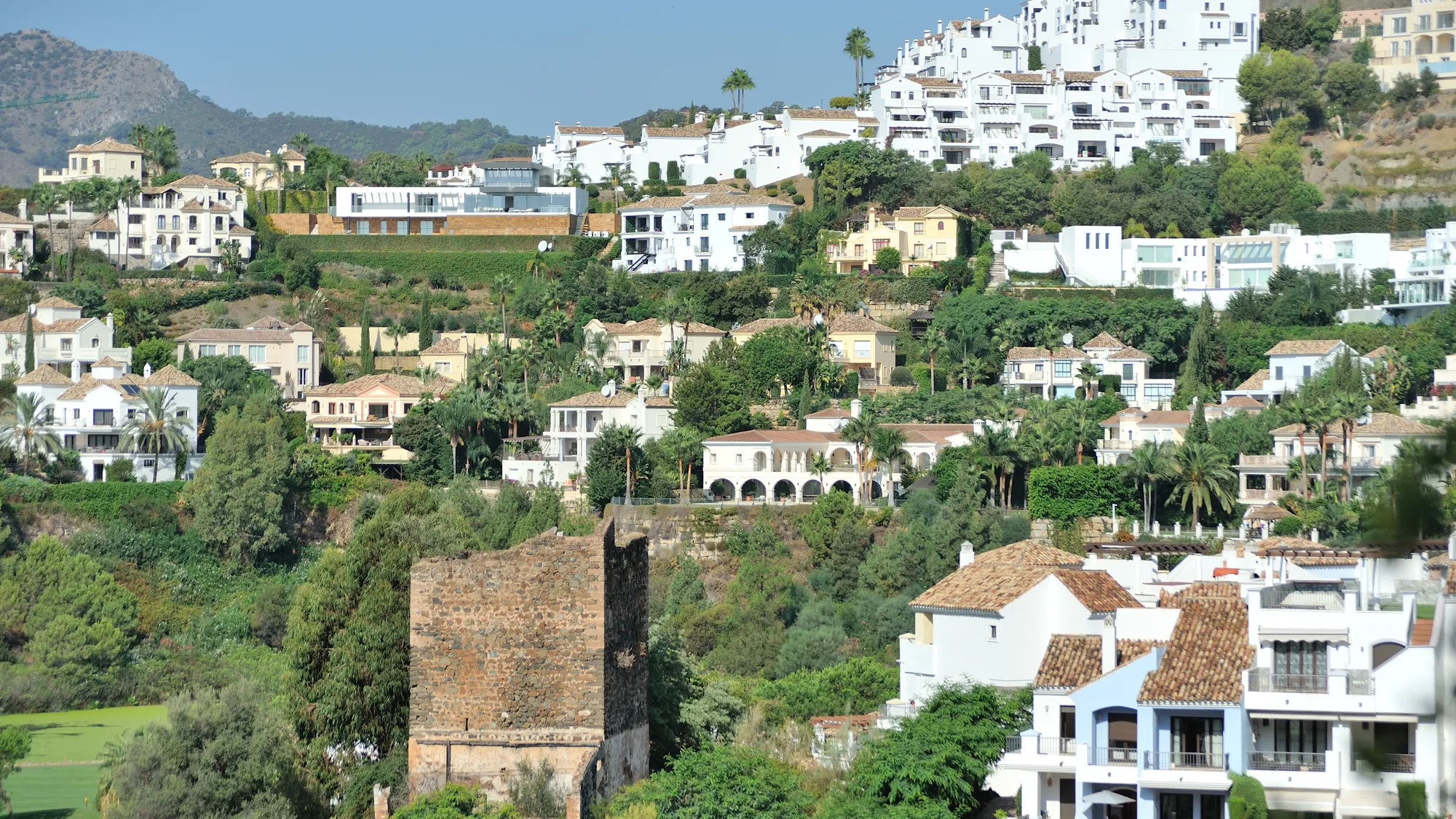 Low-rise apartment blocks and houses in a hillside urbanisation in Benahavís municipality