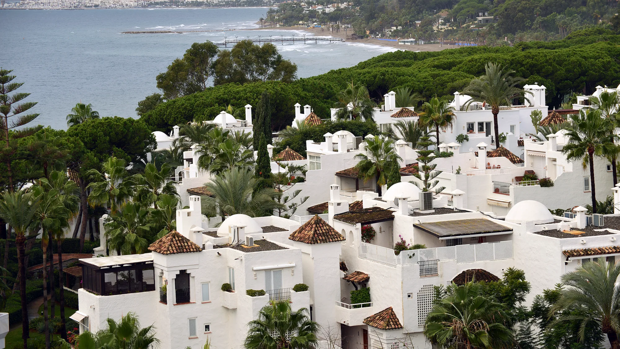 Seafront apartment buildings and gardens in Marbella seen from the beach promenade