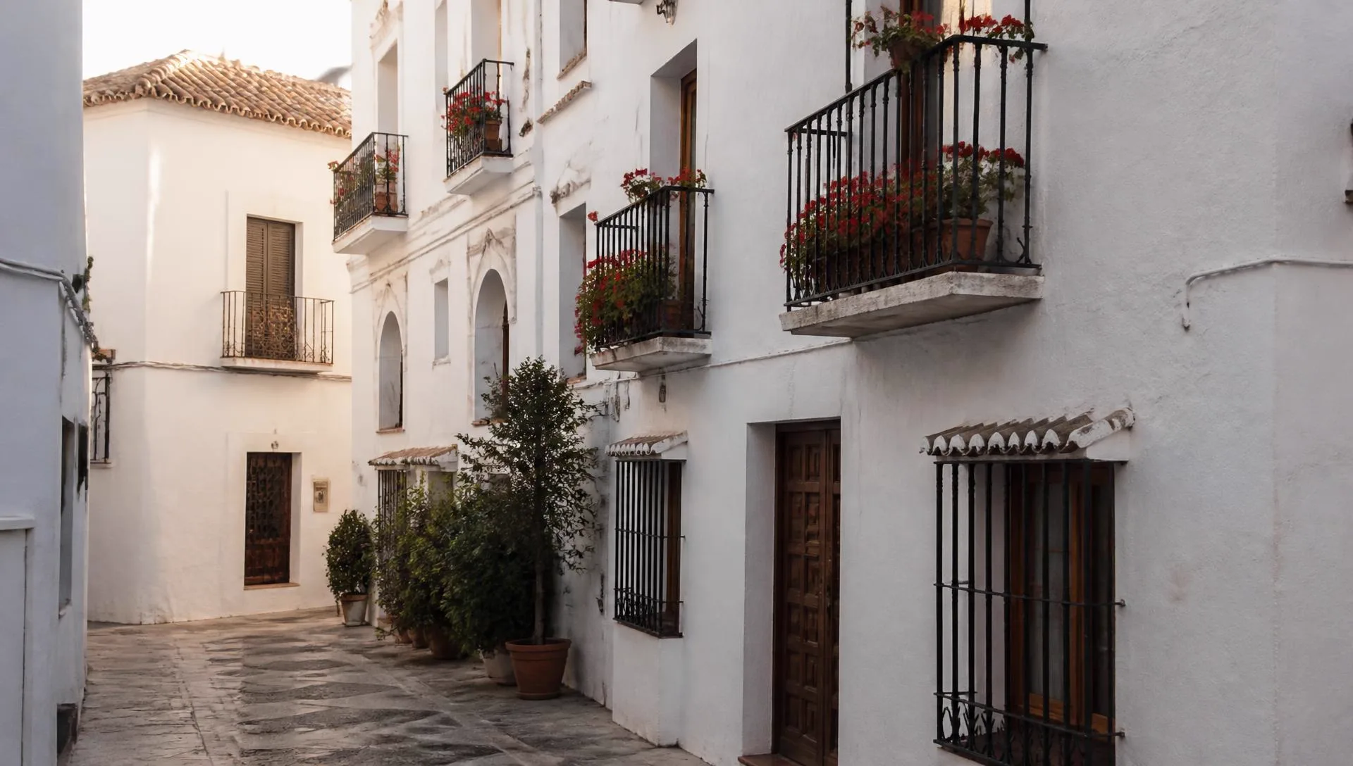 Whitewashed apartment building with wrought-iron balconies on a cobbled street in Marbella Old Town