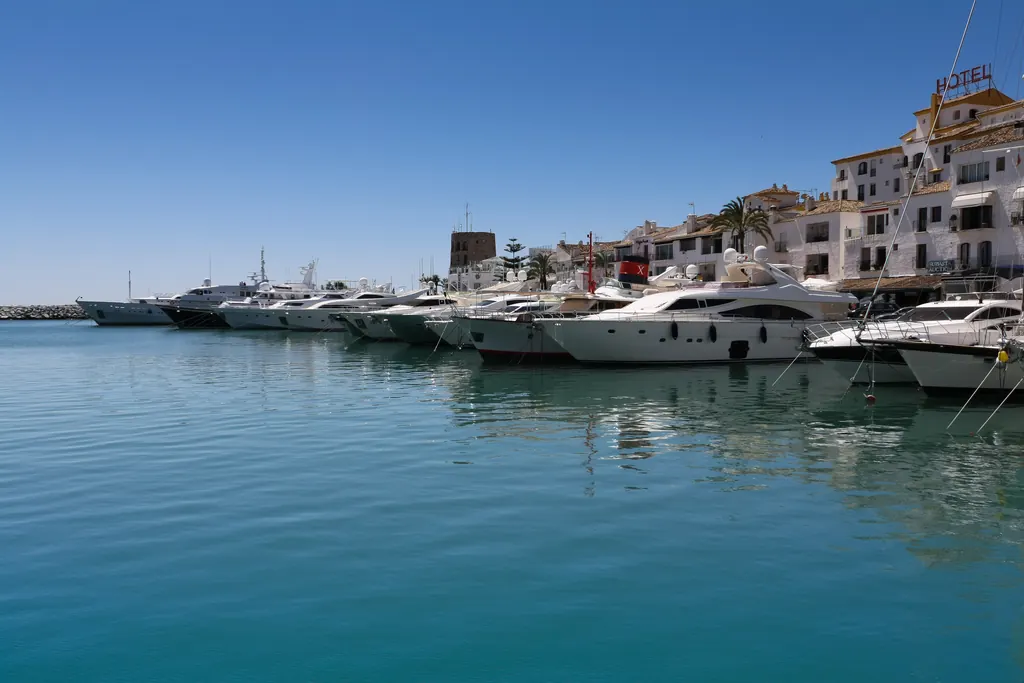 Boats moored at the Puerto Banús marina in Marbella with the harbour buildings behind