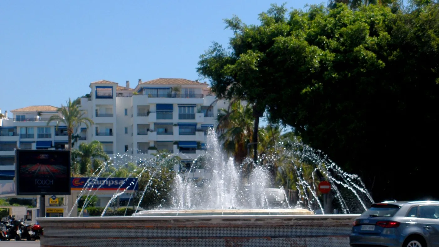 Residential apartment buildings and palm-lined street in Nueva Andalucía, Marbella