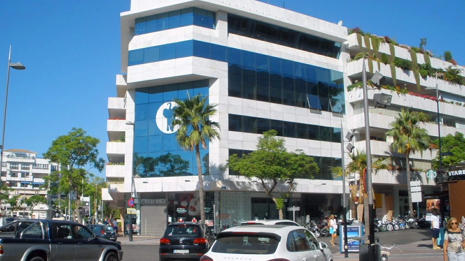 Contemporary apartment and office building with glass balconies on a street in Nueva Andalucía, Marbella