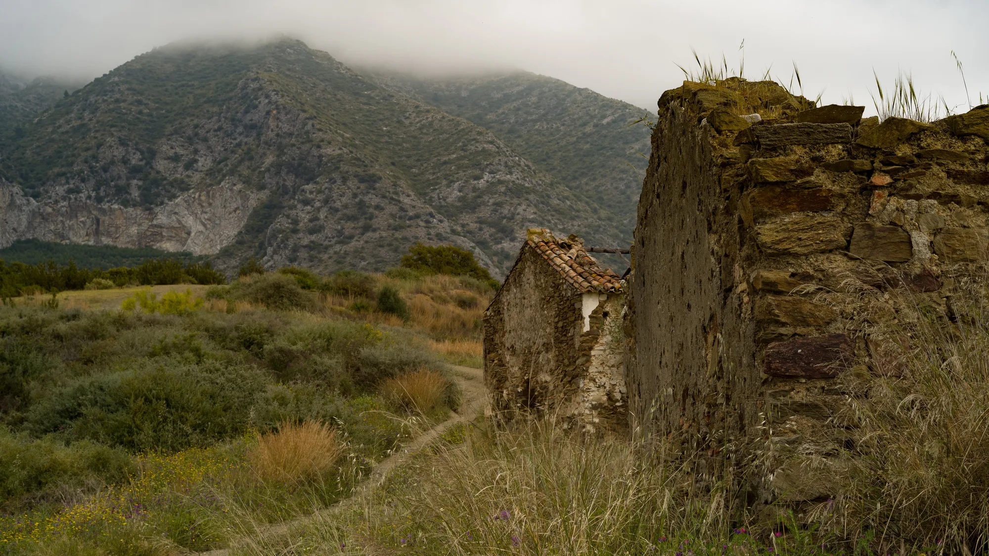 Old farmhouses on the southern hillside below the Sierra Blanca mountain range in Marbella, with La Concha behind