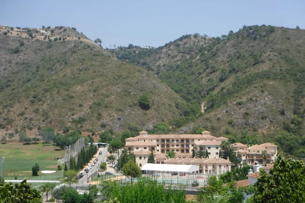 Wooded hillside in Benahavís with houses set among the slopes below the mountain ridge